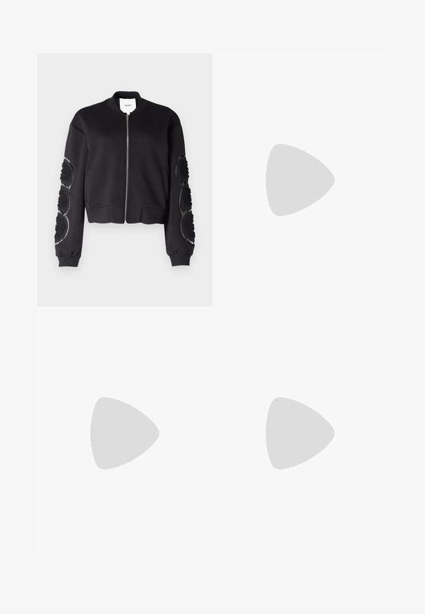 Sort bomberjakke med et cropped design, prydet med præget blomster mønster på ærmerne og en sølv lynlås. Blødt stof, ribbede manchetter.; Hvid bomulds t-shirt med korte ærmer og rund halsudskæring. Har et sort Adidas-logo på brystet og en kontrasterende sort indvendig krave.; Cremefarvede bukser med vidde, der har et zigzag-mønster, med en sort logoelastik i taljen og sorte striber på siden. Letvægtigt, tekstureret stof.; Samba sneakers i en farveskema med creme og beige, med tre lyseblå striber, hvide snørebånd og brune gummisåler.