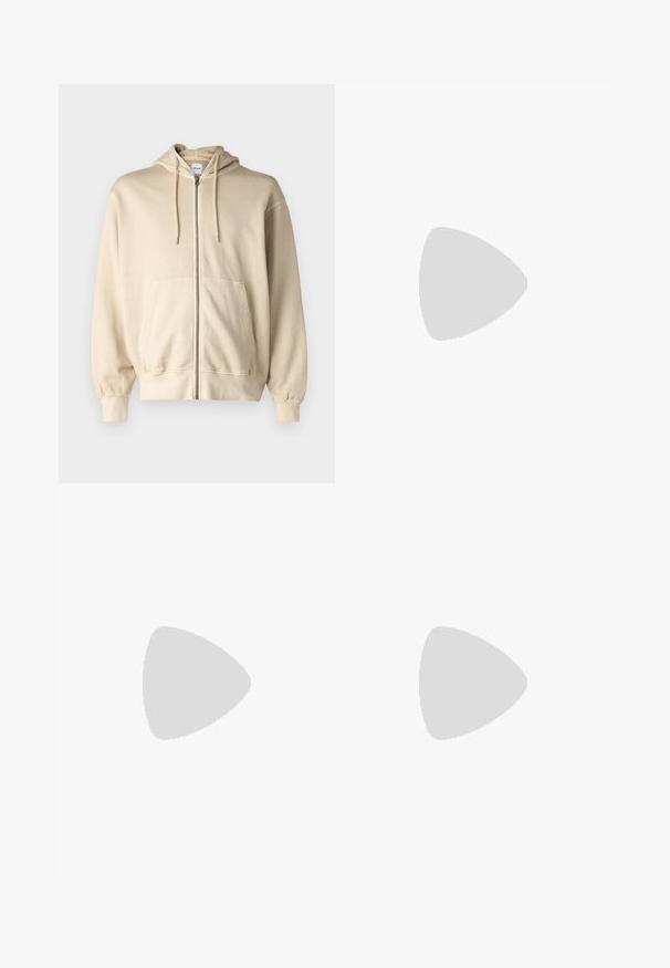 Jack & Jones JJECHARGE OVERSIZE FADED ZIP HOODIE - Jaka ar rāvējslēdzēju - humus; Balts īsām piedurknēm T-krekls ar sarkanu tekstu "Studio Originals Edition" uz kreisā krūšu, pakārtots neitrālā pelēkā fonā.; Gaiši zili džinsi ar brīvu piegriezumu, vidējo jostas augstumu un taisnām kājām. Satur piecas kabatas, jostas cilpas un pogu aizdari.; Beige zamšādas kedas ar noapaļotu purngala daļu, auklēm saplacinātu priekšpusi un teksturētu aizmugures akcentu. Balta gumijas zole nodrošina kontrastu. Vienkāršs un mūsdienīgs dizains.