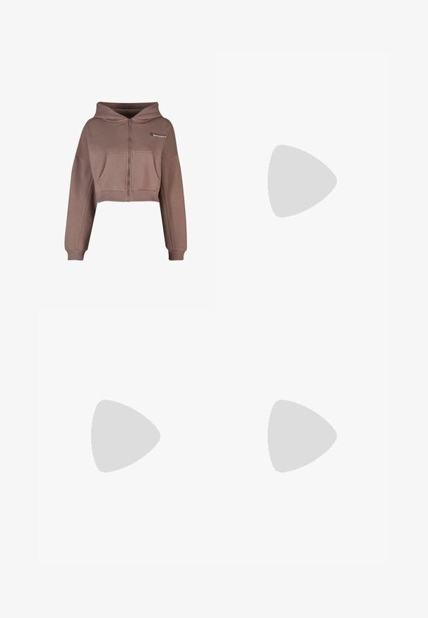 Skraćena zip-up dukserica u neutralnoj smeđoj boji. Ima prednji džep, rebrast obrub, te rebraste manžete. Sportski logo na gornjoj levoj strani.; Crni top bez rukava od pamuka, s okruglim izrezom i širokim izrezima za ruke. Glatka tekstura s ušivenim rubovima. Klasičan, minimalistički dizajn.; Svijetlosive hlače širokih nogavica od glatkog materijala. Imaju elastičnu traku u struku i crni Nike logo na lijevoj strani.; Bijele tenisice s breskvastim akcentima, glatka kožna gornja strana, perforirani vrh, teksturirana potplat i vezice. Nosi se s bijelim čarapama na plavoj površini.