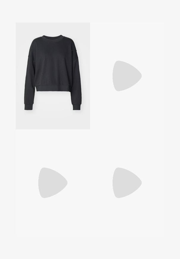 Mørk grå forkortet genser laget av mykt stoff, med rund halsutskjæring og dekorert med små svarte nagle detaljer.; Sett med tre kortermede t-skjorter i svart, grått og hvitt. Laget av bomull, med rund hals og en enkel, ensfarget design.; Grå vide ben jeans laget av denim med en glatt tekstur, med en knapp- og glidelås-lukking, og fem lommer.; Svarte sneakers i semsket skinn med hvite striper og detaljer, rund tå, yttersåle i gummigummi, kombinert med hvite ribbestrikkede crew-sokker.; Kvinne med langt mørkt hår iført et svart jakkesett, som bærer en svart skinn skulderveske, og ser over skulderen mot en hvit bakgrunn.