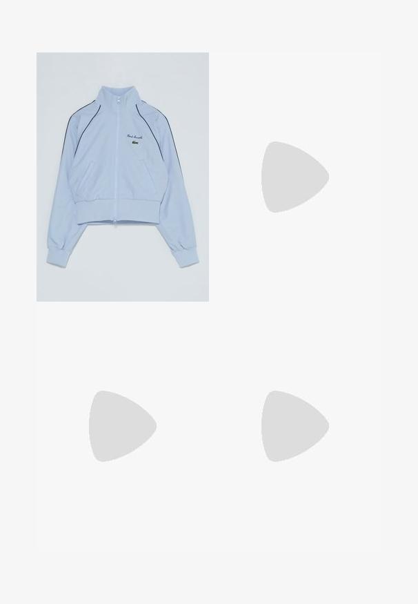 Chaqueta corta de color azul claro, hecha de tela suave, con un alto cuello, cierre de cremallera, puños elásticos y ribetes laterales negros. Logo de Lacoste bordado.; Camiseta de algodón blanca con cuello redondo y mangas cortas. Presenta un logotipo bordado en verde en el pecho. Tejido suave, corte relajado.; Pantalones de chándal blancos hechos de un suave tejido de punto. La cintura y los puños elásticos ofrecen un ajuste relajado. Diseño minimalista, sin patrones o acentos visibles.; Zapatillas deportivas blancas con parte superior de malla texturizada, sutiles acentos rosas en la suela y un logo de cocodrilo verde en el costado.