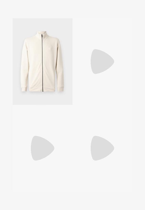 Felpa zip con collo alto di un beige chiaro, maniche lunghe e un piccolo logo sul petto. Realizzata in un materiale morbido e con texture.; Camicia bianca in cotone a maniche lunghe con scollatura rotonda, spacchi laterali in fondo e una texture liscia, mostrata da dietro.; Jeans in denim blu chiaro con design a gamba dritta, cinque tasche, chiusura con bottone, leggero sbiadimento e dettagli di cucitura a contrasto.; Sneaker bianco con tomaia in pelle liscia e profilo basso. Presenta una punta arrotondata, sei occhielli e una suola in gomma testurizzata.