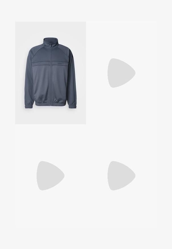 Giacca a track con zip in tessuto grigio scuro, caratterizzata da un colletto alto, polsini a costine e dettagli sul petto con righe orizzontali.; T-shirt bianca in cotone con maniche corte e scollo rotondo. Presenta un piccolo logo nero "Calvin Klein" sul lato sinistro del petto.; Jeans in denim blu chiaro con taglio dritto, caratterizzati da sezioni sbiadite, design a cinque tasche e iconico bottone di chiusura.; Sneaker nere in pelle con texture perforata, punta tonda e suola piatta in gomma bianca. Presentano lacci neri e un logo discreto sul lato.