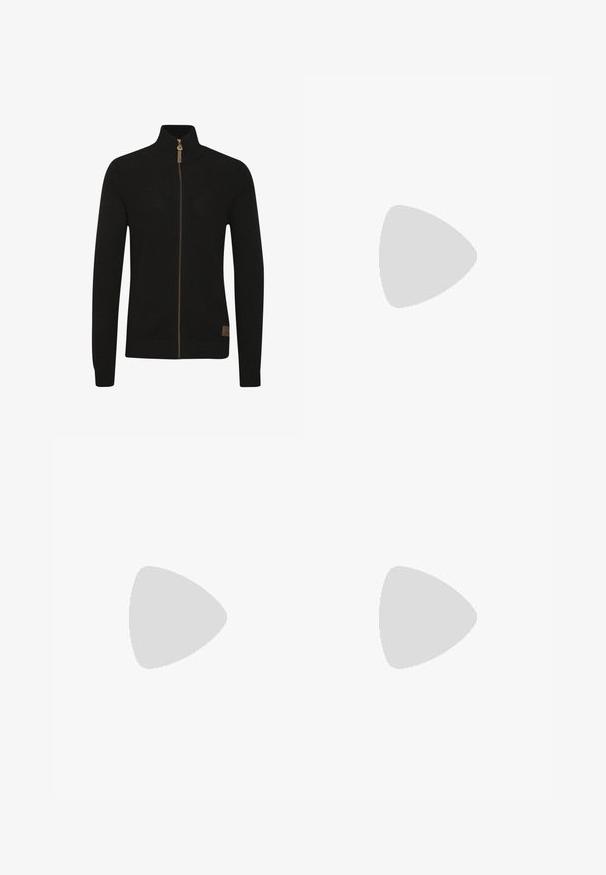 Schwarzer Reißverschluss-Pullover aus strukturiertem Strickstoff. Hoher Kragen, einfarbig, mit einem braunen Reißverschluss und einem kleinen Logo unten links.; Olivegrünes Baumwoll-T-Shirt mit einem großen schwarzen Levi's-Logo auf der Vorderseite. Klassischer Rundhalsausschnitt und kurze Ärmel, glatte Textur.; Olivgrüne Cargo-Hosen aus strapazierfähiger Baumwolle. Sie verfügen über mehrere Taschen, eine mit Reißverschluss versehene Seitentasche und ein tapered Bein mit einer leicht strukturierten Oberflächenbeschaffenheit.; Schwarzecanvas-Sneaker mit hohem Schaft, weißen Gummisohlen und Schnürsenkeln, die ein rundes Logo an der Seite besitzen und mit Denim- sowie schwarzen Hosen kombiniert sind.