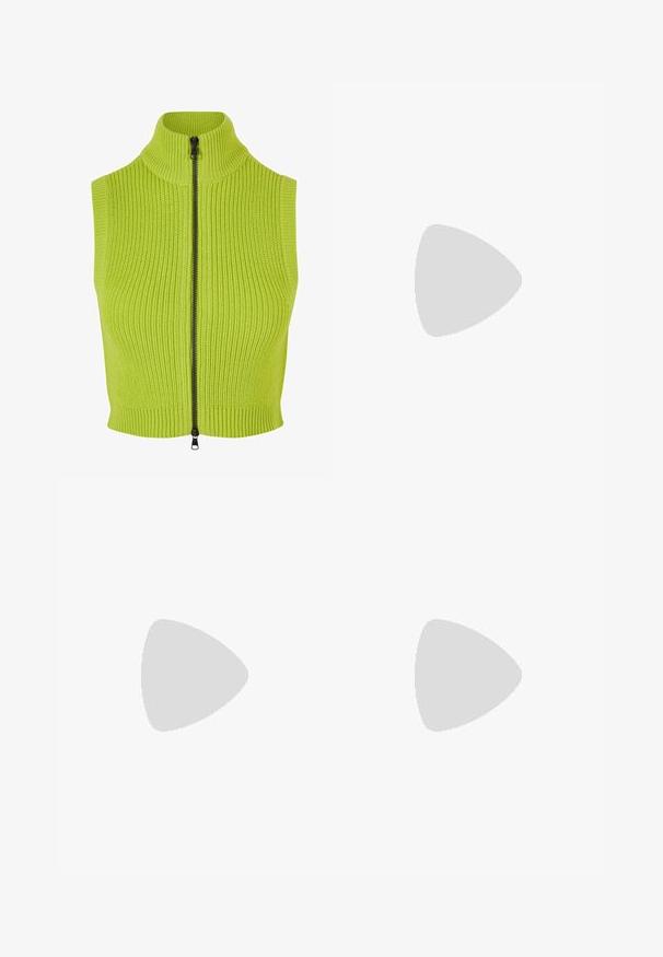 Bez rukávů pletená vesta v limetkové zelené barvě s vysokým límcem a dlouhým černým zipem. Obsahuje žebrovanou strukturu a přiléhavý střih.; Černé zkrácené tričko vyrobené z bavlny. Má krátké rukávy a kulatý výstřih. Hladký povrch s jednoduchým designem, bez dalších vzorů.; Černé široké kalhoty vyrobené z hladké, lesklé látky, s elastickým pasem bez viditelných kapes nebo kovových detailů.; Černé plátěné tenisky s bílými tkaničkami, bílým gumovým špičkovým krytem a masivní bílou střední podrážkou. Mají jemné bílé švy a gumovou podešev.