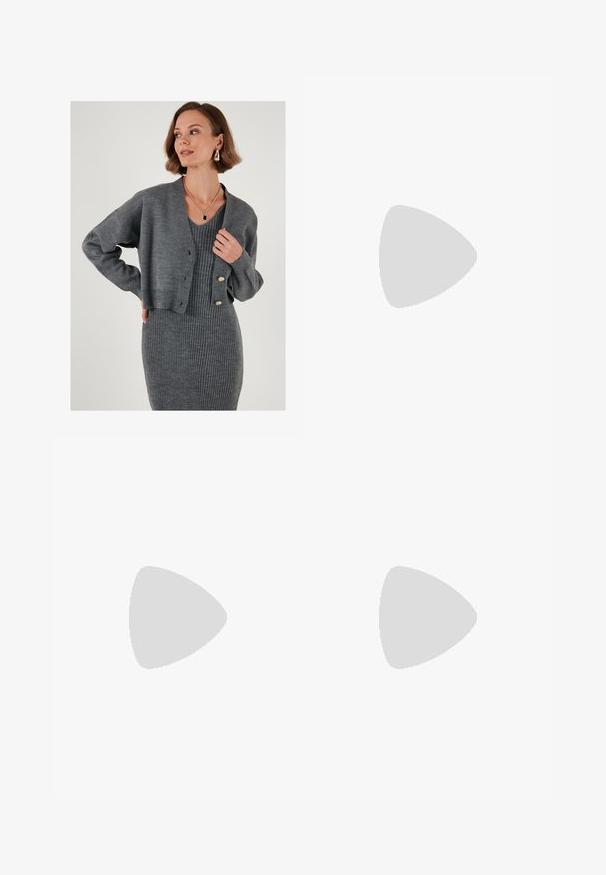 Grå stickad kofta med långa ärmar och knappar, bärs över en grå ribbad klänning. Slät textur med avslappnad passform och subtila designdetaljer.; Vit ribbade linne med rund halsringning, ärmlös design och kort längd. Märket säger "JJXX." Slät tygkvalitet.; Svarta, vida byxor med elastisk midja, tillverkade av en mjuk tyg. Har en ren design utan fickor eller synliga sömdetaljer.; Svart och grå mocka sneaker med en stor krämfärgad "N"-logotyp, lila snören och en texturerad gummisula.