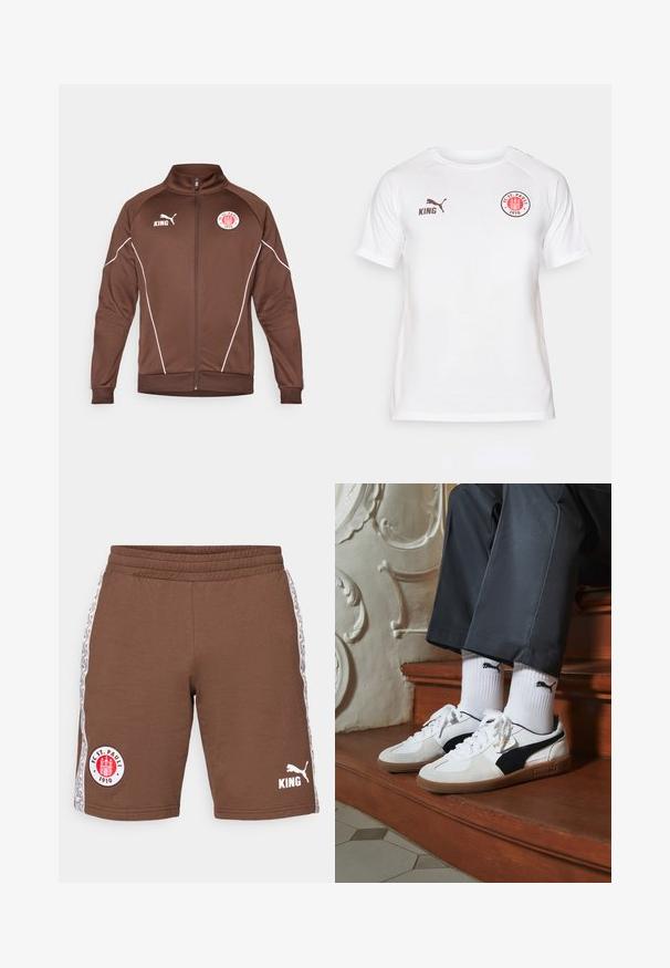 Chaqueta marrón con cremallera hecha de tela suave. Presenta líneas de acento blancas, un cuello alzado y logotipos de KING y FC St. Pauli.; Camiseta blanca de manga corta hecha de tela suave, con un logotipo circular rojo y negro en el pecho y marcas PUMA y KING en color marrón.; Pantalones cortos deportivos marrones hechos de algodón, con una cintura elástica, rayas laterales con patrones y logotipos: FC St. Pauli y Puma en blanco.; Zapatillas Puma en gamuza blanca y negra, con una suela de goma marrón. Combinadas con calcetines blancos que muestran un logo negro, llevados con pantalones oscuros.