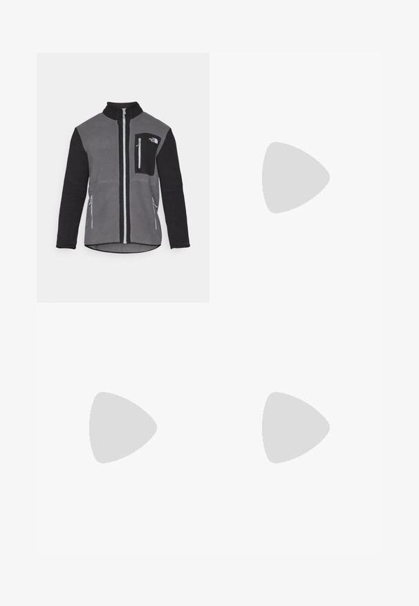Kurtka polarowa w kolorze szarym i czarnym, z wysokim kołnierzem, zamykanymi na zamek kieszeniami oraz kieszenią na piersi z logo. Miękki, teksturowany materiał.; Biała koszulka z długim rękawem wykonana z bawełny, z okrągłym dekoltem. Posiada małe czarne logo na piersi. Gładka faktura, regularny krój.; Czarne wodoodporne spodnie z regulowanymi szelkami, charakteryzujące się gładką teksturą i białym logo na lewej nodze, zaprojektowane do użytku na zewnątrz.; Czarne buty outdoorowe wykonane z siateczki i materiału syntetycznego, z fakturowaną cholewką, zabezpieczonym systemem sznurowania i solidną podeszwą, na skalistym terenie.