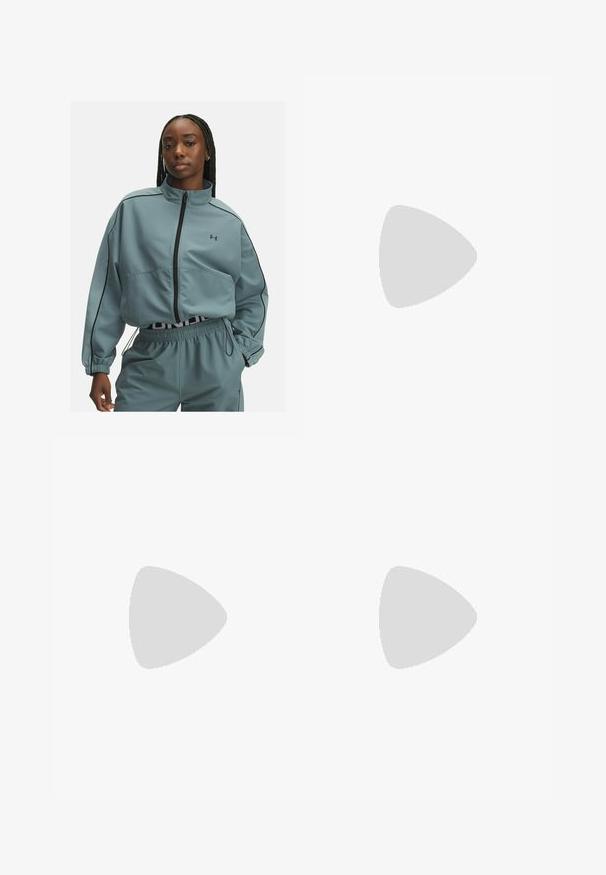 Light blue cropped jacket with a high collar, zip closure, black piping details, and an Under Armour logo on the left chest.; Short-sleeve, cropped top in light beige ribbed fabric. Features a wide scoop neckline and a snug fit, emphasizing a smooth texture.; Black leggings with a high elastic waistband featuring "UNDER ARMOUR" text. Smooth texture with subtle pattern accents along the legs.; Black athletic shoes with textured fabric, white sole, and black laces. Worn with white ribbed socks, standing on a light surface.