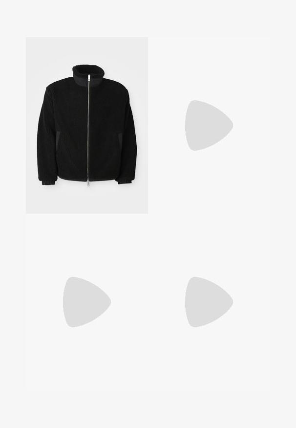 Črna flis jakna z visokim ovratnikom, polnim zadrgo in rebrastimi manšetami. Tkanina ima teksturiran, puhast videz.; Dve majice naložene: ena bela in ena črna. Kratki rokavi, okrogi izrezi, bombažna tkanina. Imajo mali moder logo na izrezu.; Svetlo modri traper hlače s ravnim krojem, pet žepov in enim gumbom za zapiranje. Dodelane s subtilnimi šivi.; Črne usnjene superge z teksturiranim zgornjim delom, podloženim ovratnikom in rdečim logotipom. Imajo debel gumijast podplat z izrazitim vzorcem.