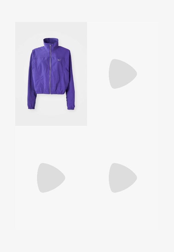 Veste zippée violette en tissu léger, dotée d'un col haut et d'un ourlet élastique, avec un petit logo sur la poitrine gauche.; Polo sans manches blanc avec un col en V, rayures grises sur les épaules et texte imprimé "Feng Chen Wang" sur le devant.; Pantalons de jogger larges rose en coton doux, dotés d'une taille élastique avec cordon de serrage et d'un petit logo blanc à l'avant.; Baskets Nike blanches et argentées avec tissu en maille, accents réfléchissants et semelle beige. Portées avec des chaussettes noires, se tenant sur une surface bleue.