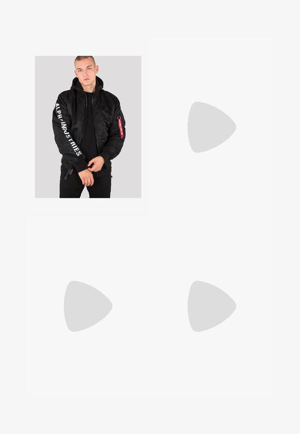 Giubbotto bomber nero con polsini a coste, chiusura con zip e scritta "ALPHA INDUSTRIES" stampata in bianco sulla manica. Presenta un'etichetta in tessuto rosso sulla tasca.; T-shirt in cotone bianco con maniche corte, scollatura a girocollo e un logo rosso sull'area sinistra del petto. Design semplice senza motivi.; Jeans in denim grigio con taglio dritto, caratterizzati da due toppe strappate sulle ginocchia e un classico design a cinque tasche.; Sneaker nere New Balance 1000 con pannelli in mesh testurizzato e suede, suola ammortizzata e dettagli grigi; indossate con calzini bianchi a coste.