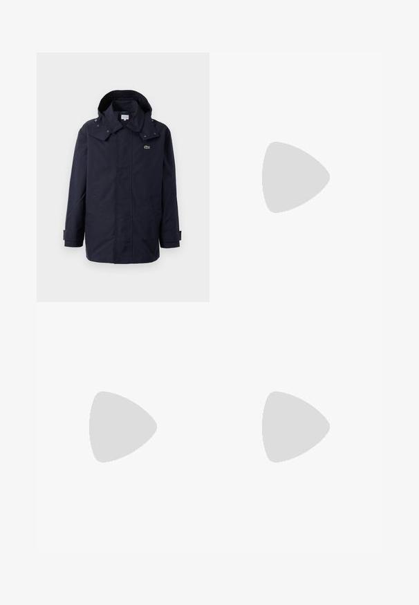 Marineblauwe waterdichte jas met capuchon, voorzien van drukkers, zijzakken en een klein groen krokodillenlogo op de borst.; Lichtblauw katoenen t-shirt met een ronde hals en korte mouwen. Heeft een klein geborduurd groen alligatorlogo op de borst.; Witte linnen broek met een elastische tailleband, rechte pijpen en een enigszins gestructureerde stof. Geen patronen of extra details.; Witte leren sneaker met ronde neus, vetersluiting aan de voorkant en zwarte hakaccent. Beschikt over een klein geborduurd krokodillenlogo aan de zijkant.