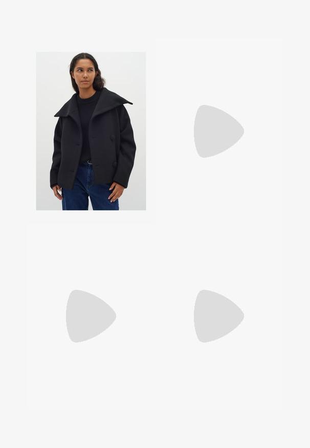 Cappotto in misto lana nero con un ampio colletto, due grandi bottoni e una vestibilità rilassata. Indossato sopra un maglione nero e jeans in denim blu.; Maglione nero a maglia con tessuto testurizzato, vestibilità comoda e maniche ampie, abbinato a jeans azzurri chiari.; Gonna lunga con stampa leopardata realizzata in tessuto liscio. Base beige con macchie nere e marroni. Design svasato con orlo dritto.; Mocassino in pelle nera con dettagli a frangia, cuciture lungo il bordo e una suola in gomma spessa per una maggiore durata.