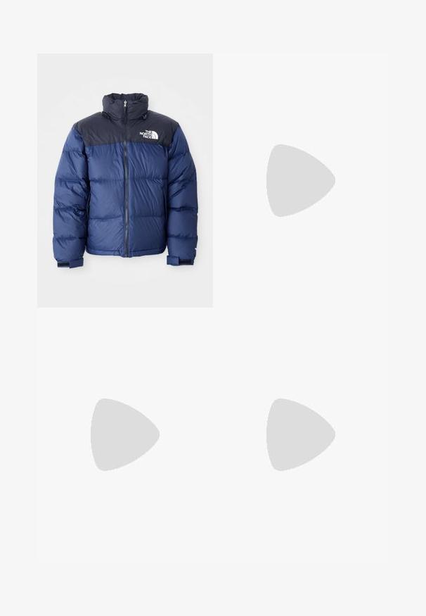 Mørkeblå puffjakke med svart toppseksjon, høy krage, glidelås foran og logo på brystet. Bulkete tekstur og elastiske mansjetter.; Lys lilla genser, bomullsblanding, rund hals, ribbede mansjetter og nederkant, med en liten hvit logo øverst til venstre på fronten. Glatt tekstur.; Etikett med tekst på flere språk, omsorgssymboler og resirkuleringsikoner, trykt på et mykt stofflignende materiale i lys farge.; Sorte joggesko laget av semsket skinn og lær, med en blå logo og brun gummisåle. Paret med grå sokker og kordfløylebukser.