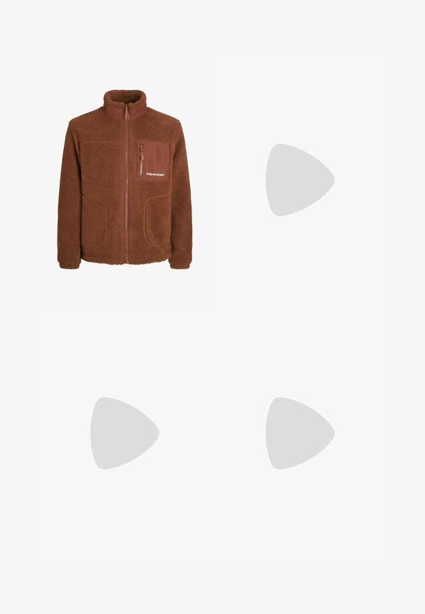 Braune Fleecejacke mit hohem Kragen, durchgehendem Reißverschluss, zwei seitlichen Taschen und einer Brusttasche. Verfügt über eine weiche Textur und ein Logodetail.; Langärmliges weißes Hemd aus glattem Baumwollstoff, mit klassischem Kragen und vorderem Knopfverschluss, ohne Muster oder Akzente.; Rostfarbene Hosen mit verblasster Textur, ausgestattet mit zwei großen, fransigen Ausschnitten an den Knien und normalen Taschen.; Füße in beigen, gewebten Adidas-Sneakern mit Gummisohlen und weißen Knöchelsocken auf grüner texturierter Fläche.