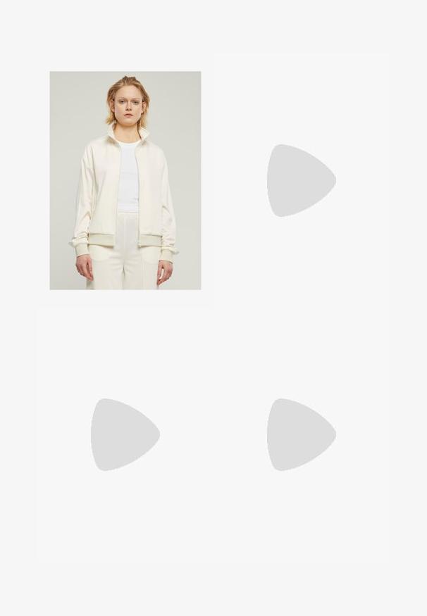 Krémová zipová bunda s vysokým golierom, rebrovanými manžetami a bočnými vreckami. Jednofarebná s hladkým povrchom, kombinovaná s bielym tričkom pod ňou.; adidas Performance Športové tričko - earth strata/white; Čierne cyklistické kraťasy vyrobené z elastického materiálu, s vysokým pásom a plochými švami pre pohodlie a trvanlivosť.; Béžová atletická obuv s ružovým logom trojpruhov, textúrovaný sieťový zvršok, polstrovaný golier a biela gumová podrážka s označením "LIGHTSTRIKE".