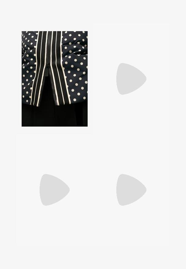 Námořnická modrá péřová bunda s puntíky, která má kontrastní bílý zip a pruhovaný lem podél přední části. Hladká textura, krátké rukávy.; Dvě bavlněné podprsenky: jedna v světle béžové a druhá v černé barvě, s tenkými ramínky a designem ve tvaru V. Viditelné štítky uvnitř.; Černá sukně s bílými puntíky, vyrobená z měkké látky. Má rovný střih a rozparek na spodním okraji pro usnadnění pohybu.; Černé kožené sandály na podpatku s křížovým páskem, čtveratou špičkou a hranatým podpatkem. Hladký povrch s minimálními detaily.; Černá kožená kabelka přes rameno s zakřiveným designem, se strukturovaným popruhem a zlatým kováním na horním uzávěru. Hladký povrch.