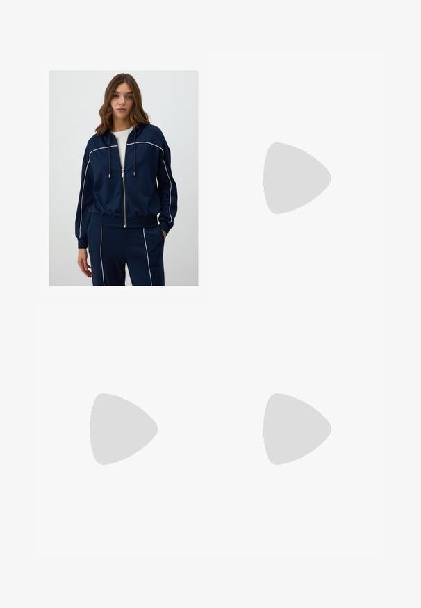 Navy blue zip-up hoodie made of soft fabric, featuring white piping along the shoulders and sleeves, with a drawstring hood and relaxed fit.; White fitted top made of ribbed fabric with cap sleeves and gathered details at the sides for texture and shape.; White wide-leg pants made of soft fabric. Features an elastic waistband with a drawstring and a smooth texture. No visible patterns or hardware.; Stradivarius Trainers - white