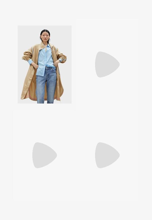 Beige oversized jacket with blue accents, worn over a light blue shirt with a subtle pattern, paired with blue jeans. Smooth, textured fabric.; Black oversized t-shirt featuring a graphic of a bear with the text “NOT CUTE BUT WILD” in bold, white lettering. Cotton material.; Light blue, high-waisted jeans made of denim. Feature wide legs, two torn knee areas, and classic five-pocket styling.; White high-top canvas sneaker with black rubber sole, front rubber toe cap, and six eyelets for laces, featuring a clean, minimalist design.