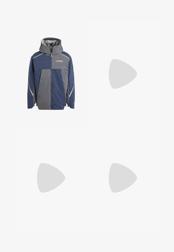 Adidas Terrex NATIONAL GEOGRAPHIC INSULATED REVERSABLE - Winterjas - grey six; Zwarte korte mouwen t-shirt van lichtgewicht stof, met een lichtgrijze "TERREX" logo over de borst en een ronde hals.; Zwarte sweatpants van zacht materiaal; met elastische tailleband, smalle pijpen en ritszakken aan de zijkanten. 'TERREX'-logo in het wit gedrukt.; Zwarte sportieve schoenen met een gestructureerde gebreide bovenkant, verstevigde neus en een gevoerde zool, tentoongesteld op aardse grond met verspreide takjes.