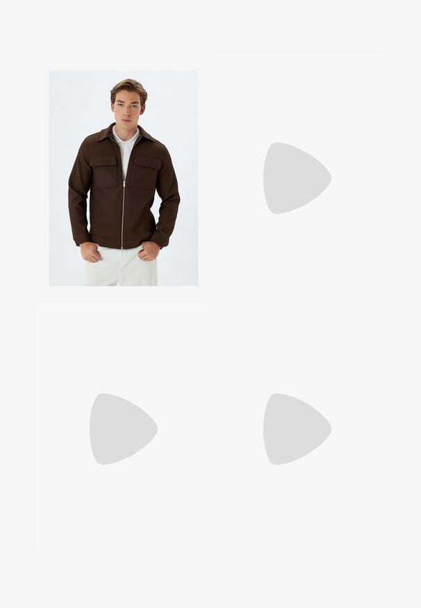Bruine geribbelde jas met een ritssluiting aan de voorkant, twee borstzakken en een kraag. Gecombineerd met witte broeken, die een gestructureerde stof en een getailleerde pasvorm tonen.; Witte t-shirt met korte mouwen van katoen, met een ronde hals en een relaxte fit met rechte zoom. Geen patronen of versieringen.; Zwarte wijde broek met geplooide voorkant, zijzakken en een gladde stoftextuur. Ontworpen voor een ontspannen pasvorm.; Zwarte klompen met een afgeronde neus, brede band en twee gespen. De kurken voetbedtextuur contrasteert met het gladde, matte rubberen exterieur.