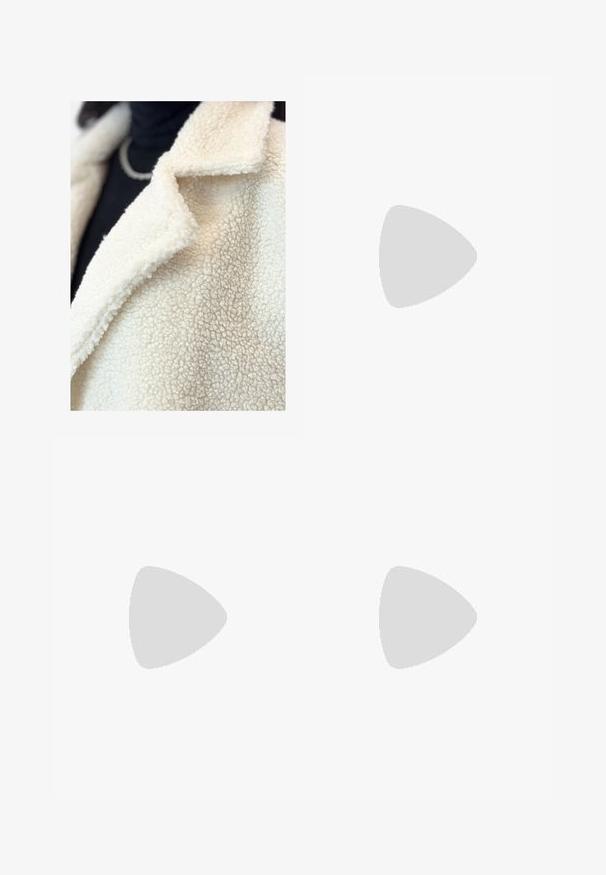 Cremefarvet falsk shearling-frakke med klapkrave, der har en blød, struktureret overflade og minimal syning, lagd over en sort bluse.; Hvid bomulds T-shirt med rund halsudskæring og korte ærmer. Enkel design, glat tekstur, ingen mønstre eller detaljer.; Højtaljede sorte denim jeans med en bred benklip, fem-lomme design og synlig syning. Stoffet har en glat, let tekstureret finish.; Hvide lædersneakers med glat tekstur, polstret ankeldel og perforeret tå. Har en let hævet gummisål og snørebåndsdesign.