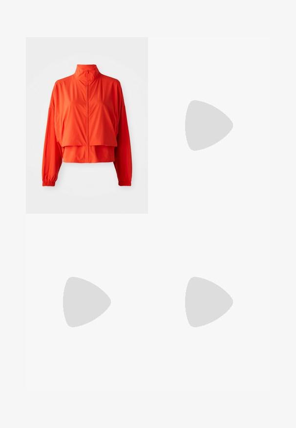 Rød kort jakke laget av lett, glatt stoff. Har høy krage, glidelås foran og brede, elastiske ermer.; Kuttet svart hettegenser laget av bomull, med hvit trykk av "NIKE" og "SPORTSWEAR", med ribbestrikkede mansjetter og krage.; Blå og hvite stripete shorts med elastisk midje og et merke med Nike-logoen. Laget av lett materiale med en glatt tekstur.; Hvite idrettssko med en teksturert overdel, med rosa accenter på snøringene og store luftblærer i sålen.