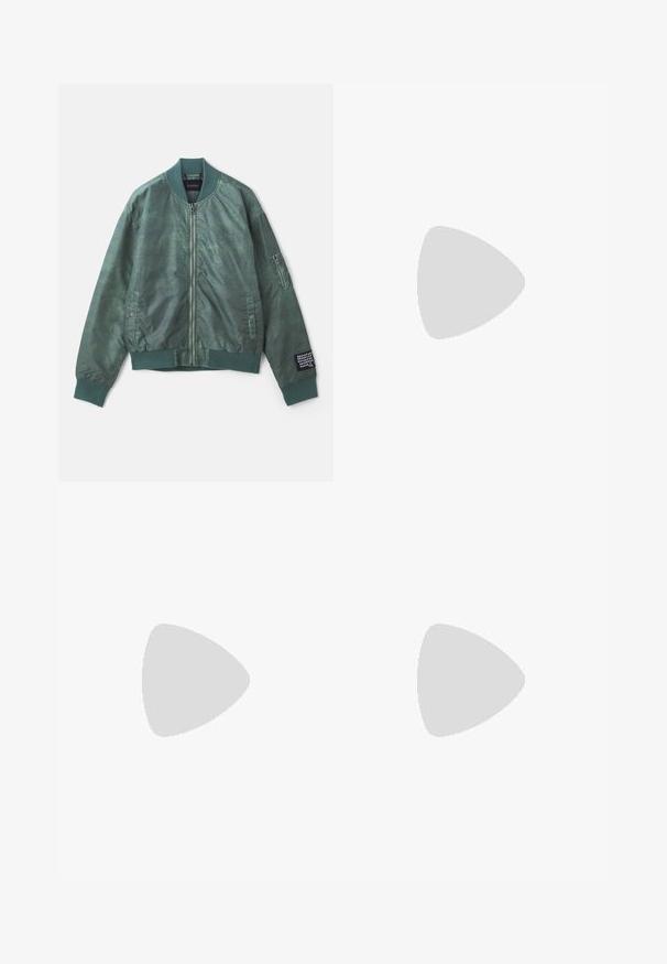 Veste bomber verte en tissu texturé, dotée d'une fermeture éclair sur le devant, d'un col côtelé et de poches latérales. La manche gauche comprend une poche zippée.; T-shirt en coton noir à manches courtes, col rond, avec un logo EA7 brodé jaune sur la poitrine gauche. Texture lisse.; Pantalons de jogging couleur crème avec des rayures noires sur les côtés, taille élastique et poignets côtelés. Tissu doux avec une coupe décontractée.; Baskets en cuir noir avec semelles en caoutchouc blanc, dotées de lacets ronds, d'une surface lisse et d'un logo discret sur le talon. Portées avec un jean bleu.