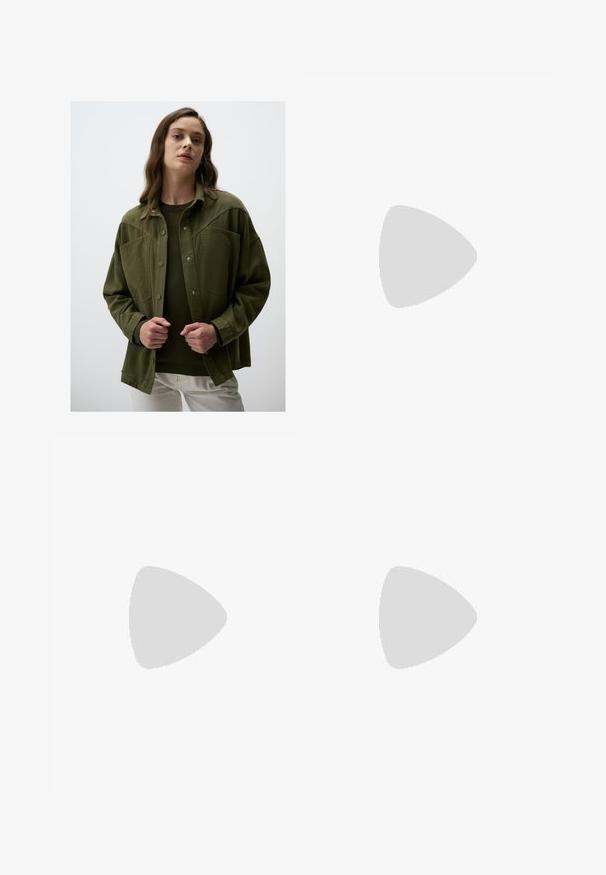Veste oversize vert olive avec des boutons-pression, poches poitrine et une texture lisse, portée par-dessus un pull vert foncé et un pantalon blanc.; Chemise à rayures jaunes avec manches longues, col pointu et fermeture à boutons sur le devant. Présente des rayures verticales bleues et une coupe ajustée.; Jean large marron en denim, avec une fermeture à bouton à l'avant, cinq poches et des détails de couture visibles.; Chaussure slingback beige clair avec un bout pointu, une texture en daim doux, ornée de deux boucles décoratives et d'un petit talon plat.