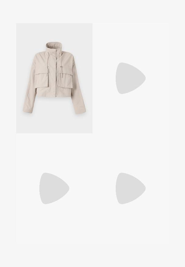 Veste beige raccourcie en tissu léger, dotée d'un col montant, d'un cordon de serrage ajustable et de deux grandes poches à rabat à l'avant.; T-shirt à manches courtes présentant un imprimé léopard beige avec un grand motif d'orchidée rose au centre. Tissu doux avec une finition arrondie.; Jean large bleu foncé en tissu denim avec des coutures blanches, doté de deux poches avant et d'une fermeture à boutons classique.; Sandales en cuir marron avec deux boucles ajustables, semelle en liège et semelle en caoutchouc texturé, portées pieds nus sur un sol en béton.