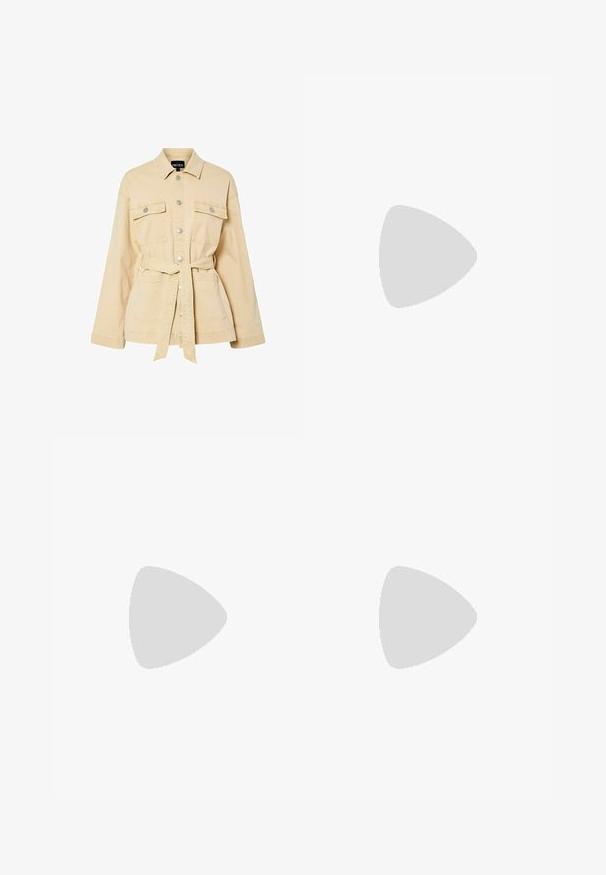 Beige jasje met riem, gemaakt van katoen-twill, voorzien van metalen drukknoopsluitingen, twee borstzakken en een gestructureerde kraag. Zachte textuur en ontspannen pasvorm.; Witte fitted top van ribstof met korte mouwen en geplooide details aan de zijkanten voor textuur en vorm.; Witte hoge taille jeans met een ruime pijp, gemaakt van denim; heeft vijf zakken, koperen klinknagels en een ritssluiting.; Blauwe suède schoenen met roze strepen en witte veters, voorzien van een gumrubberen zool, gecombineerd met losse denim broek op een groene ondergrond.