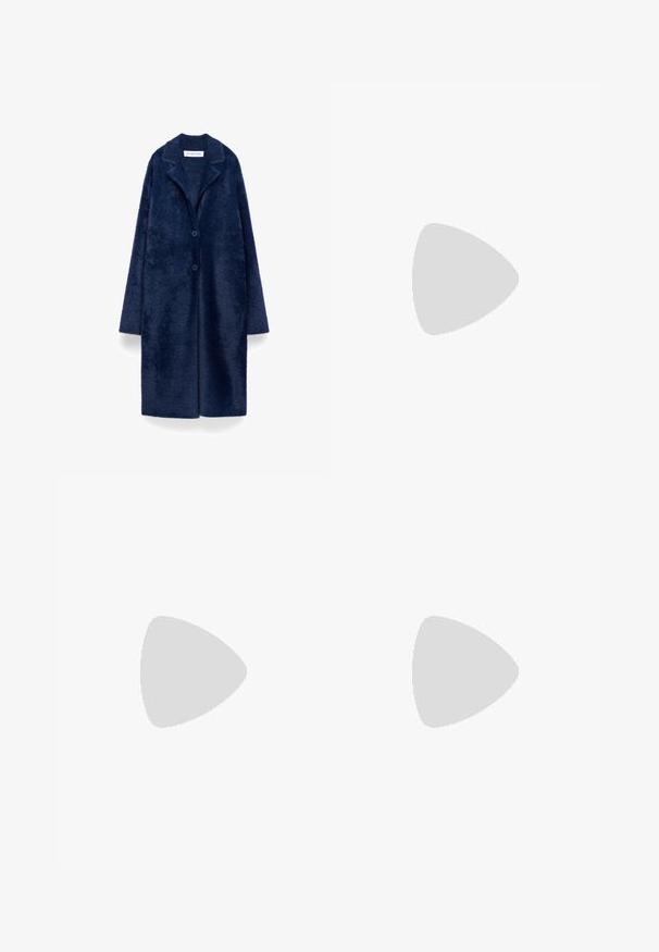 Lange marineblauwe donzige jas met twee knopen, brede reverskraag en lange mouwen, gemarkeerd Adolfo Dominguez.; Witte korte mouwen t-shirt van katoen. Heeft een ronde halslijn en een ontspannen pasvorm. Glad textuur zonder zichtbare patronen of accenten.; Zwarte denim broek met wijde pijpen en een hoge taille, voorzien van voor- en achterzakken, gestikte naden en een knoopsluiting. Gladde textuur.; Zwarte slipper met twee gouden gesps, gladde textuur, platte zool en een minimalistisch ontwerp.