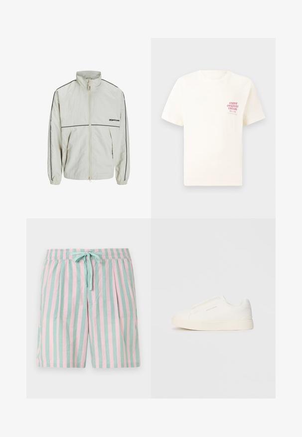 Giacca leggera in crema con colletto alto, zip frontale e strisce nere ai lati; presenta polsini elastici e un logo sobrio sul davanti.; T-shirt bianco a maniche corte con testo rosso "Studio Originals Edition" sul lato sinistro del petto, esposto su uno sfondo grigio neutro.; Pantaloni corti leggeri a righe con strisce verticali alternate in teal e rosa, vita elastica e dettaglio con fiocco frontale.; Sneakers bianchi slip-on con superficie texturizzata, suola spessa e design minimalista. Presentano il logo del marchio sul lato.