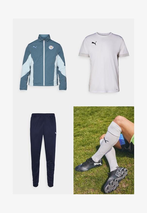 Windbreaker-Jacke in Dunkelblau und Hellblau, mit durchgehendem Reißverschluss, hohem Kragen und dem Manchester City-Logo auf der Brust.; Weißes kurzärmeliges Sportshirt mit Rundhalsausschnitt, ausgestattet mit atmungsaktiven Netzdetails an den Seiten und einem schwarzen Puma-Logo auf der Brust.; Marinefarbene Sporthosen aus leichtem Material, mit elastischem Bund und schmal zulaufenden Beinen. Kleines weißes Logo auf der Seite.; Schwarze Fußballschuhe mit strukturiertem Obermaterial, weißen Akzenten und passenden knielangen weißen Socken mit einem Logo. Gras-Hintergrund.