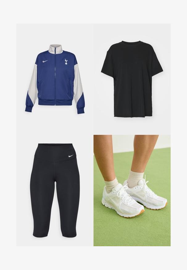 Námořnická modrá zipová bunda s šedými rukávy, s vysokým límcem, logem Nike a emblémem Tottenham Hotspur. Vyrobena z hladkého materiálu.; Černé tričko s krátkým rukávem vyrobené z hladkého materiálu, s kulatým výstřihem a volným střihem. Obsahuje boční rozparky pro větší pohodlí a prodyšnost.; Nike černé capri legíny mají vysoký pas, hladký strečový materiál a jemný logo detail na přední straně.; Bílé sportovní boty s síťovinou, gumovými podrážkami a béžovými detaily. Nosené se světlými ponožkami na zeleném povrchu.