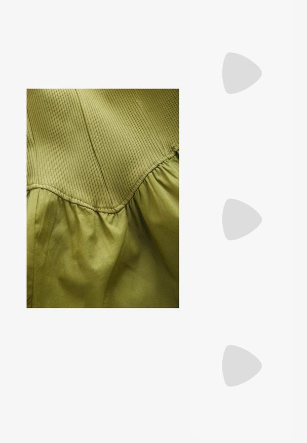 Sininen sidottu t-paita lyhyillä hihoilla, jossa on pyöreä kaula-aukko ja keltainen-oranssi soikea logo, jossa lukee "STIEG" edessä.; Oliivinvihreä kangas, jossa on pystysuora raidallinen rakenne yläosassa ja pehmeä laskostettu pinta alapuolella, kaarevilla saumoilla.; Valkoinen Moon Boot, jossa on tekoturkista valmistettu yläosa, nauhakiinnitys edessä ja kumipohja. Rakeinen pinta ja kohokuvioitu logo sivulla. Tyylikäs, pehmustettu muotoilu.; Vaaleanpunaiset läpinäkyvät aurinkolasit, joissa on kulmikas kissansilmämuoto, tummat linssit ja kohokuvioitu teksti templeissä lukien "AURINKOLASIT."