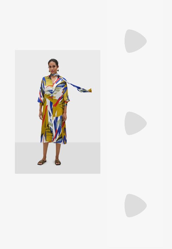 Abito colorato di lunghezza al ginocchio con audaci motivi geometrici in giallo, blu, rosso e verde. Presenta un colletto e una sciarpa abbinata.; Slingback bianco con punta affusolata, materiale superiore liscio, tacco basso a blocco e design con ritagli laterali, dotato di cinturino regolabile con fibbia.; Occhiali da sole rotondi con lenti scure e montatura dorata. Il modello indossa un cardigan leggero azzurro a costine con bottoni e maniche bianche a contrasto.; Wristlet Michael Kors in tela rivestita beige con motivo a logo MK ripetuto, hardware dorato e tracolla a catena staccabile.
