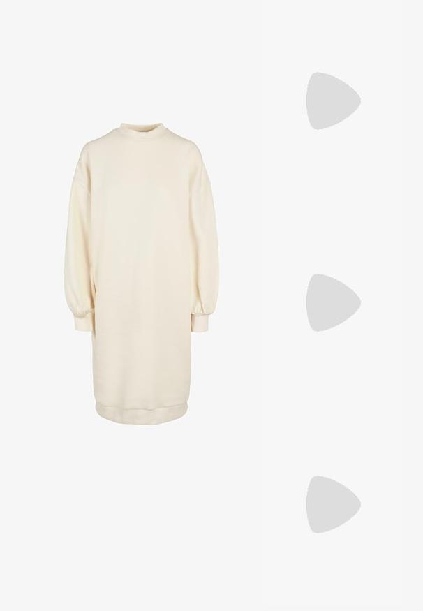 Jasno beżowa sukienka w formie pulowera z wysokim dekoltem, długimi bufkami, ribbowymi mankietami oraz prostym krojem, wykonana z miękkiej mieszanki bawełny.; Czarne lakierowane półbuty na obcasie z wydłużonym noskiem i geometrycznym słupkiem. Charakteryzują się eleganckim, minimalistycznym designem oraz gładką fakturą.; Czarna skórzana torba hobo o gładkiej fakturze, zaokrąglonym kształcie i pojedynczym, regulowanym pasku; posiada szerokie otwarcie na górze.; Złote kolczyki w odcieniu, prezentujące teksturowane, faliste kształty. Zawierają rzeźbiarskie klipsy i otwarty projekt kółek z młotkowanym wykończeniem.