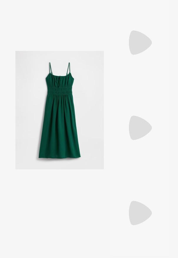 Abito verde realizzato in tessuto testurizzato, con spalline a spaghetti regolabili e un corpetto arricciato, che sfocia in una gonna a balze.; Scarpa slingback in vernice nera con punta affusolata, cinturini alla caviglia con fibbie in argento e accessori, e tacco sottile.; Borsa a mano metallica dorata con un design strutturato, superficie liscia e tracolla regolabile. Presenta una forma triangolare unica e cuciture minimaliste.; Orecchini in tono oro caratterizzati da forme ondulate eTexture. Comprendono chiusure clip-on scultoree e un design a cerchio aperto con finitura martellata.