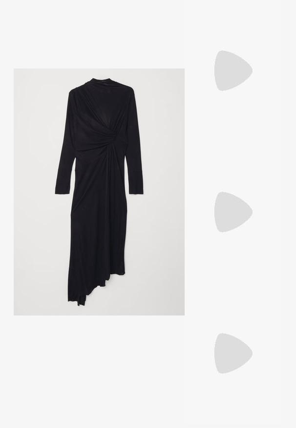 Must mustaga pikkade varrukatega kleit, millel on drapeeritud disain, vöökoht on keeratud detailiga ja voolav asümmeetriline hem. Pehme kangastekstuuri.; Mustad nahast loafers madala kontsaga, millel on esiküljel dekoratiivne kuldne detalj ja sile tekstuur.; Must musta kott, millel on struktureeritud kuju, sile tekstuur ja metallist klamber. Kombineeritud laiate mustade pükstega ja avatud varvaste sandaalidega puidust põrandal.; Kuldse kõrvarõngad, millel on tekstuuritud disain ja kolm selget kristalli ühel küljel, pakkudes modernset geomeetrilist esteetikat.