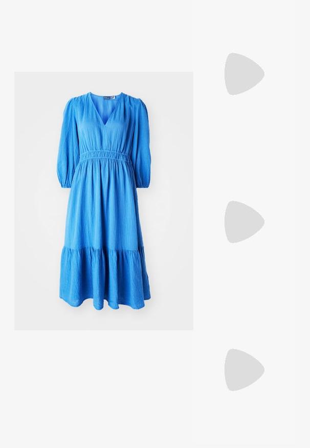 Blauwe jurk met een V-hals, lange puffmouwen en een elastische taille. Beschikt over een gespeelde rimpelzoom en een gestructureerde stof.; Witte leren sneakers, laag model, met een gladde textuur, ronde neus, vetersluiting aan de voorkant en een klein geborduurd logo aan de zijkant.; Zwarte leren halfronde tas met een gouden hardware accent, voorzien van een ritssluiting. Draagt crossbody over een grijze trui.; Gouden knoopstuds met een gedraaide design. Elke oorring heeft een ronde transparante achterkant voor een veilige draagervaring.