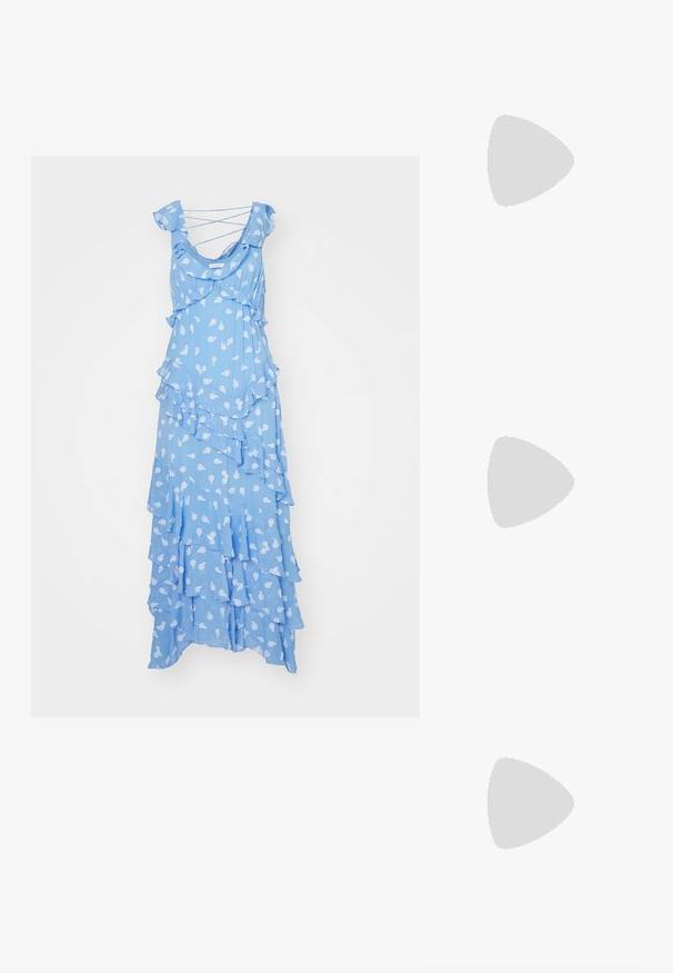 Robe maxi superposée bleu clair en tissu doux. Présente des couches froncées et un imprimé floral avec de fines bretelles croisées.; Escarpin en cuir verni noir à talon haut, avec un bout pointu, une bride réglable à la cheville et des côtés ouverts. Texture lisse.; Lunettes de soleil couleur crème avec des verres ovales, teinte noire et accents de logo métallique au niveau des tempes. Texture lisse, design œil de chat.; Sac à main noir à la forme structurée, texture lisse et fermoir métallique. Associé à un pantalon noir ample et des sandales ouvertes sur un sol en bois.