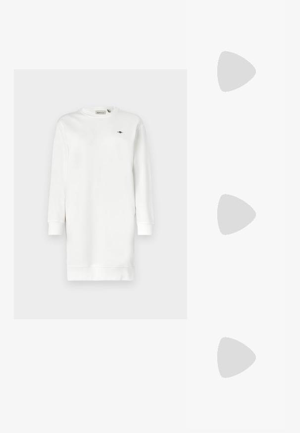 Fehér pamut keverékből készült hosszúujjú ruhapulóver, bordázott mandzsettákkal és kis hímzett logóval a mellrészen.; Fekete lakkbőr bokacsizma ívelt orral, elasztikus oldalpanelek és vastag blokk sarkal. A hátsó részen dombornyomott logó található.; Fekete bőr válltáska puha tapintással, háromszög alakú, állítható pánttal, világoskék csíkos inggel és fehér nadrággal párosítva.; Aranyszínű, félhold alakú fülbevalók, polírozott felülettel és zsanéros záródással. A sima textúra és a fényes felület fokozza a láthatóságot.