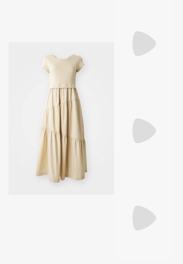 Beige mekko, jossa on lyhythihainen yläosa ja kerroksellinen, hulmuava hame, jossa on poimutetut saumat. Valmistettu pehmeästä kankaasta, jossa on sileä pinta.; Musta lakattu slingback-kengät teräväkärkisellä muotoilulla, kahdella hihnalla, kultaisilla pyöreillä yksityiskohdilla ja matalalla paksupohjalla.; Musta tikattu nahkakäsilaukku, jossa on kultaketju ja toggle-lukko, jossa on pyöreä aksentti. Kompakti suorakulmainen muoto.; Korvashäntäkorvakorut kullansävyllä, joissa on mustat emalikoristeet. Korvakoruissa on teksturoitu muotoilu ja pieni kirkas kivi yksityiskohtana.
