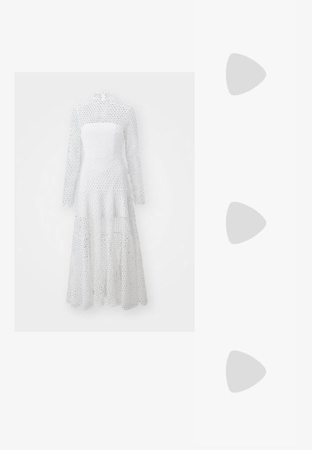 Rochie albă cu mâneci lungi și guler înalt, confecționată dintr-un material cu model din dantelă circulară, având un tiv fluid și în trepte.; Pantofi din piele neagră, cu șireturi, cu vârf rotund, suprafață texturată și talpă groasă din cauciuc. Purtați cu pantaloni negri răsuciți, pe un fundal de beton.; Ochelari de soare dreptunghiulari negri cu lentile verzi închise, confectionați din plastic, având detalii din metal aproape de lentile și logo-ul brandului pe bratul ochelarilor.; Geantă de mână din piele neagră, cu o formă curbată, având un închizător oval auriu proeminent, curea ajustabilă și un design minimalis.