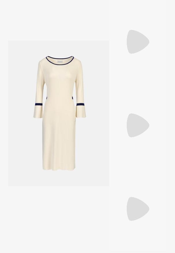 Kremasta pletena haljina s tri četvrtine zvonastih rukava, s tamnoplavim detaljima na izrezu i manžetama, te bočnim džepovima. Jednostavan, uski dizajn.; Crne lakirane slingback visoke potpetice s šiljastim vrhom, zaobljenim izrezom i blok potpeticom. Sadrži akcent zlatnog tona s kopčom.; Crne prevelike sunčane naočale s gradijentnim lećama, debelim okvirom i zlatnim lancem kao detaljem na krakovima.; Crna torba od sintetičkog materijala, s jednostavnim pravokutnim dizajnom, zlatnim kvadratnim detaljima i dvostrukim ručkama.