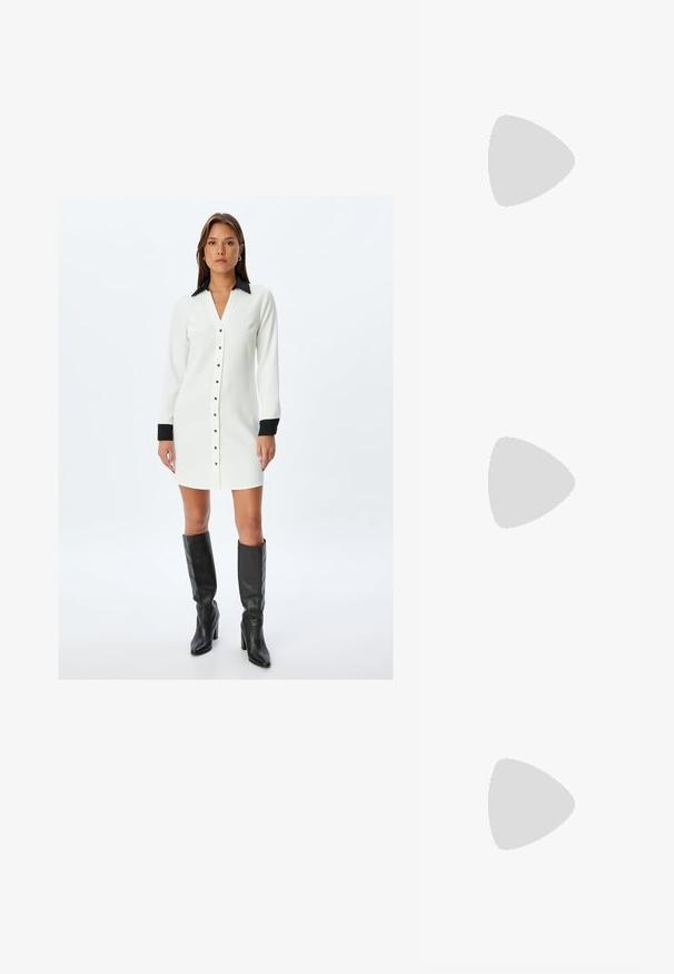 Hvid skjorte-kjole med sort krave og manchetter, med lige snit, lange ærmer og metalliske knapdetaljer.; Sorte patentlæder slingback hæle med spids tå, udskåret sideskærm og en lille firkantet hæl. Glat tekstur med minimale detaljer.; Sort læderhåndtaske med en buet form, aftagelig rem og guldfinish. Tasken har en klap med en spænde detalje.; Guldfarvet metalarmbånd med flydende, kurvet design. Har en lille, fremtrædende sølvfarvet accent i den ene ende.