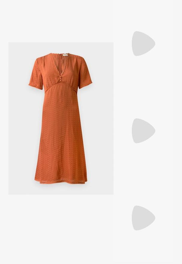 Vestido de manga corta en color óxido con un patrón texturizado. Presenta un escote en V y un cierre de botones en la parte delantera, con una silueta acampanada y fluida.; Zapatillas de cuero blancas, diseño de corte bajo, con una textura suave, puntera redonda, cordones en la parte delantera y un pequeño logo bordado en el lateral.; Bolso negro de cuero en forma de media luna con un acento de hardware dorado, con cierre de cremallera. Llevado cruzado sobre un suéter gris.; Pendientes de botón en tono dorado con un diseño retorcido. Cada pendiente cuenta con un respaldo circular transparente para una sujeción segura.