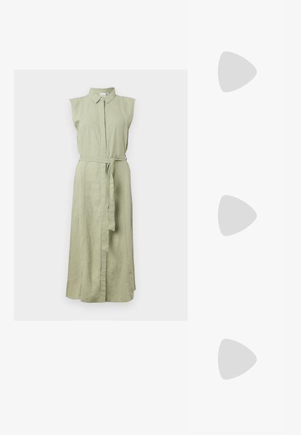 Rochie fără mâneci, cu nasturi, din in verde deschis, cu guler și talie accentuată cu curea. Prezintă o siluetă dreaptă și slituri laterale.; Sneaker alb cu un upper sintetic neted, cu vârf perforat, șireturi plate și o talpă texturată, expus pe o suprafață de lemn.; Ochelari de soare negri, supradimensionați, cu lentile degradate, rame groase și detalii cu lanț de ton auriu pe brațele templului.; Geantă de umăr din piele ecologică maro, cu o formă curbată, cusături minime și un accent din metal auriu. Are un închidere cu fermoar în partea de sus și o curea ajustabilă.